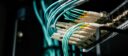 Detailed view of network cables plugged into a server rack in a data center.